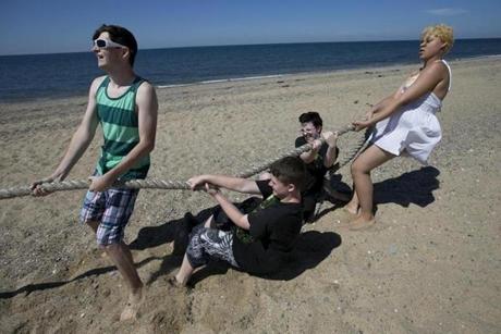 From left, Andrew Lawless, Morgan Yeager, Dan English, and Ghia Parow put their backs to a tug of war at Herring Cove Beach in Provincetown.
