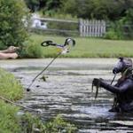 A member of the Connecticut State Police Dive Team threw a metal detector to a diver in the water July 30. 