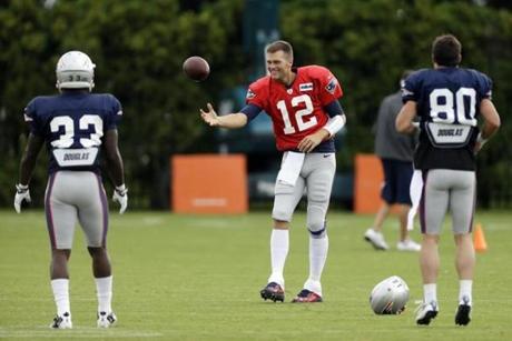 Tom Brady (flanked by Leon Washington and Danny Amendola) worked his magic with the football during Wednesday’s session vs. the Eagles. (AP Photo/Matt Rourke)
