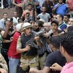 An army officer pointed his weapon at the crowd Saturday as he helped an Islamist man leave Cairo’s Fath mosque where supporters of ousted president Morsi were holed up. Security forces were trying to convince the supporters to leave.