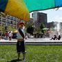 Sam Lottner played with a rainbow-colored parachute on the Rose Fitzgerald Kennedy Greenway in Boston.
