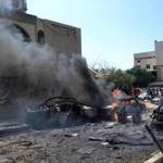 Burned and destroyed cars are seen at the entrance of a mosque, left, which was attacked by a car bomb, in the northern city of Tripoli.