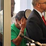 Steven Chan, a middle school teacher in Newton, shielded his face in Newton District Court during his arraignment on child pornography possession and dissemination charges. At right is his lawyer, Christopher Shannon. 