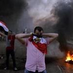 A protester covered his face with a flag as Muslim Brotherhood supporters and security forces clashed in Cairo Friday.