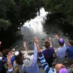 Members of the Shir Hadash congregation took part in a Tashlich service on Rosh Hashanah, symbolically casting away sins by throwing bread into moving water, at the pedestrian bridge over the Charles River at Albemarle Street in Newton. 
