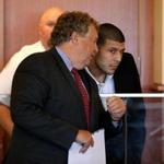 Attorney Michael Fee talked with his client, Aaron Hernandez, at Hernandez’s arraignment in Fall River.