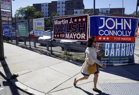 Campaign signs competed for attention on a fence along Dorchester Avenue on Thursday.
