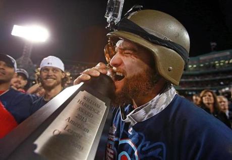 Jonny Gomes bit the William Harridge Award after the Red Sox beat the Tigers to advance to the World Series.
