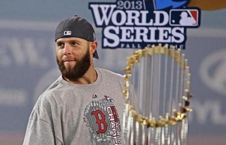 Dustin Pedroia is seen with the World Series trophy.

