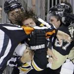 Referee Eric Furlatt, left, broke up a fight between Boston Bruins' Torey Krug and Pittsburgh Penguins' Sidney Crosby during the second period.