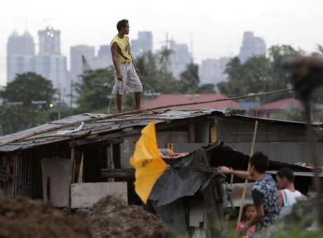 A Filipino resident stood on a roof of a home in Manila.
