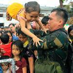 Philippine military personnel helped as Typhoon Haiyan survivors in Tacloban waited for evacuation flights Tuesday.