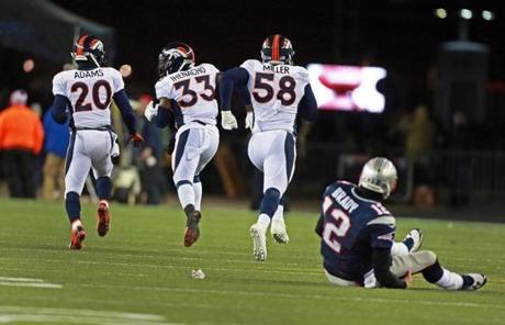 Tom Brady watched as Von Miller (second from right) headed to the end zone after recovering Stevan Ridley's fumble.
