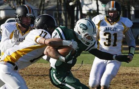 Nauset played at Dennis-Yarmouth in football on Thanksgiving morning.  Michael Dunn stretched for extra yardage over Nauset’s Frankie DeStefano.
