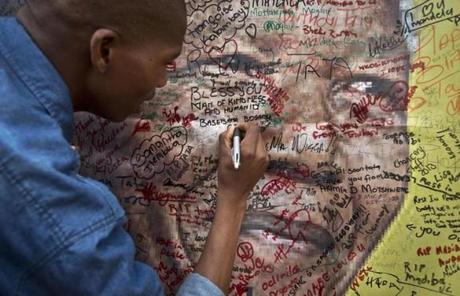 A man wrote a message on a poster of Mandela outside Mandela's old house in Johannesburg, South Africa.
