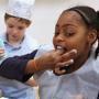Third-grader Ahnya Hospedales sampled some icing as she and fellow classmates from the James F. Condon Elementary School decorated gingerbread cookies, baked by the culinary staff of the Boston Convention and Exhibition Center in South Boston.