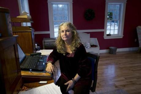 Author Lauren Slater writes and works on her jewelry in a small cottage with red walls at her home in Harvard.
