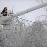 A worker cleared iced branches from power lines in Waterville, Maine, on Monday.