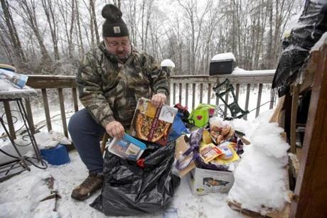 Tom Henson sorted through food he has been keeping cold on the deck of his home in Litchfield, Maine, where many people have been without power since Monday.
