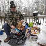 Tom Henson sorted through food he has been keeping cold on the deck of his home in Litchfield, Maine, where many people have been without power since Monday.