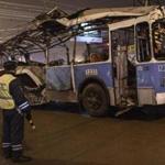 A police officer watched as a bus, destroyed in an earlier explosion, was towed away in Volgograd. 