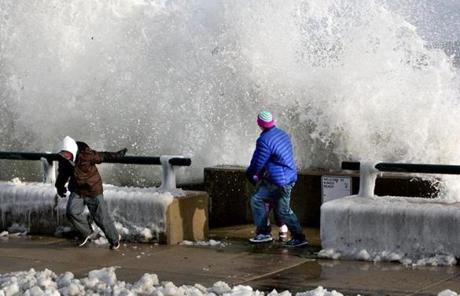 Youths ducked spray as huge waves crashed against the seawall at King's Beach in Lynn.
