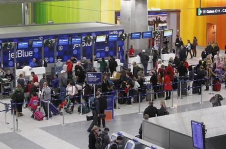 Passengers waited in a long line at Logan Airport's Terminal C on Sunday.
