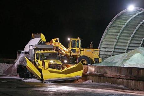 Crews loaded salt into trucks off the Massachusetts Turnpike in Weston for use on roads through the night.
