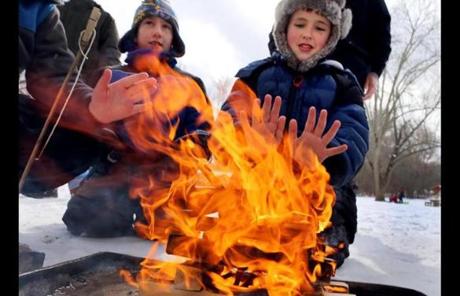 Joey McCoy (left), 10, of Peabody and Tom Davidson, 9, of Peabody kept warm by a fire they lit. 
