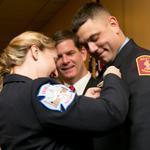 Boston firefighter Janice Parsons pinned a badge on her husband and new fellow firefighter Trenton Parsons Tuesday in a ceremony at Florian Hall attended by Mayor Martin J. Walsh.
