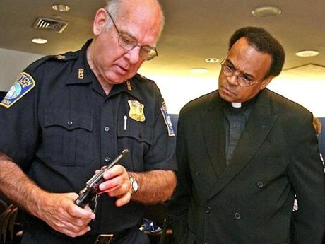 Boston Police Superintendent-in-Chief Albert Goslin,left, and  Reverend Shawn Harrison examined one of 382 firearms turned in during a gun buyback in Boston in 2006.
