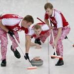 Russia's vice Alexey Stukalskiy, center, delivered a stone as Russia's Peter Dron and Evgeny Arkhipov swept during their men's curling round robin game against Britain. 