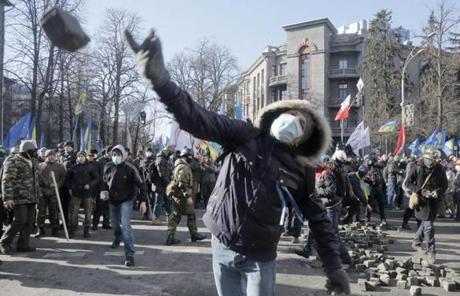 An anti-government protester threw a stone during clashes with riot police in Kiev, Ukraine.
