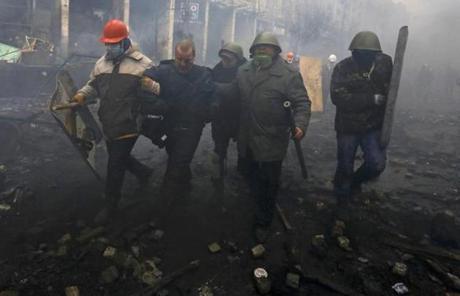 Protesters captured a police officer (second to left) during clashes in Kiev.
