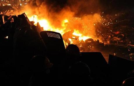 A protester threw tires to keep a barricade of flames between protesters and police at Independence square in Kiev on Wednesday. 
