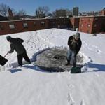 Workers cleared snow from a Boston rooftop.