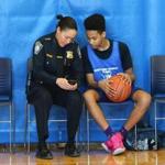 Boston Police Deputy Superintendent Nora Baston spent time with Emanuel Green, 15, of Dorchester as she showed him photos on her smartphone during a break in the action.