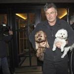 Alec Baldwin walked out of his New York apartment building carrying two dogs in New York last year.