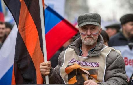 A man carried a flag and wore a sign that said “Motherland and Freedom!” in Moscow in support of Russians in Ukraine.
