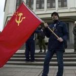 Residents of Simferopol, Ukraine, held Soviet flags as a Cossack militia guarded the Crimean Parliament on Thursday.