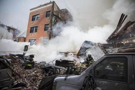 Heavy smoke poured from the debris as the New York Fire Department  responded to a 5-alarm fire and building collapse.
