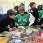 After a Methuen Fun Hockey League practice, Luke Henry and his 6-year-old twin brother, Gavin, look through stack of books brought in by town librarians as part of the league’s Skate & Read program. 
