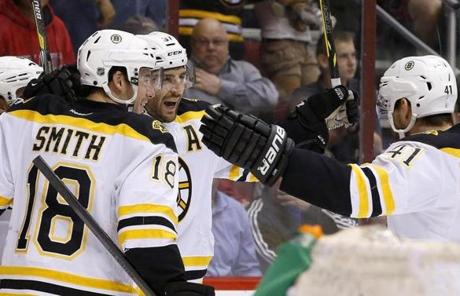 Boston Bruins' Patrice Bergeron, second from left, celebrates his goal against the Phoenix Coyotes with teammates Reilly Smith (18) and Andrej Meszaros (41), of the Czech Republic, during the first period of an NHL hockey game on Saturday, March 22, 2014, in Glendale, Ariz. (AP Photo/Ross D. Franklin)
