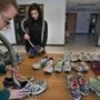 Tiffany Locke (left) and Emily Shafer prepared shoes for the exhibit, which will open on April 7.