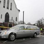 A hearse and limousine were covered in plastic and police tape in front of the Church of St. Peter in Plymouth.