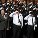 The hearse carrying Plymouth Police Officer Gregg Maloney receives a salute from fellow officers at the Plymouth Police Headquarters.