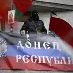 A masked pro-Russian activist looked from a balcony of the regional administration building decorated with a banner reading “Donetsk Republic.”