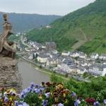 A gargoyle on the castle in Cochem, Germany, has a vantage point over the Moselle Valley, its steep vineyards, and the riverside town.