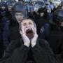 A pro-Russian protester shouts slogans in front of Ukrainian riot police in central Donetsk last month. International issues color the International Monetary Fund’s world outlook.