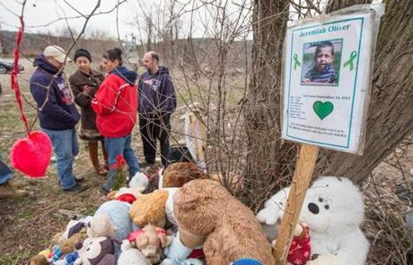 People gathered near a makeshift memorial outside the former home of Jeremiah Oliver in Fitchburg. 
